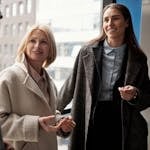 A diverse group of business professionals conversing in an urban office setting.